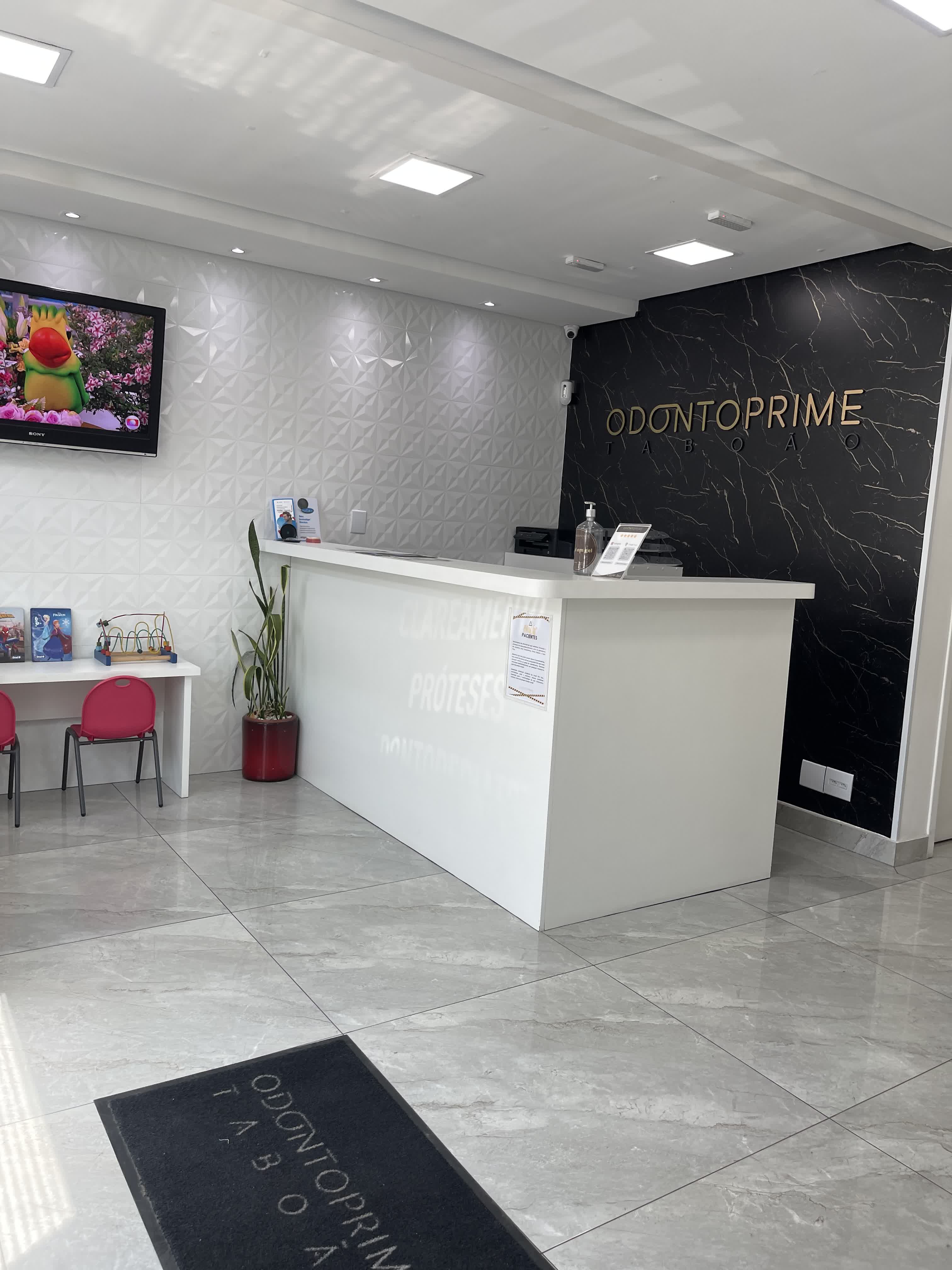Recepção da Odonto Prime Taboão — mármore preto e logo dourado